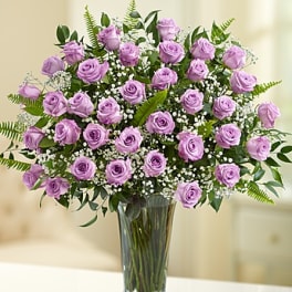 Lavender roses arranged in a clear glass vase