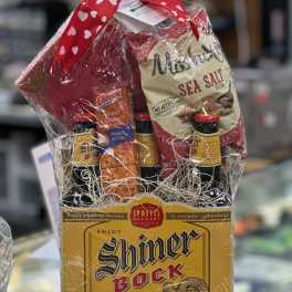 Gift basket with beer bottles, snacks, and a bag of chips wrapped in cellophane