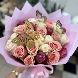 Bouquet of pink and white roses wrapped in lavender paper