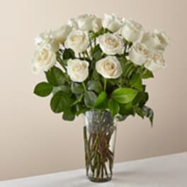 White roses arranged in a clear glass vase