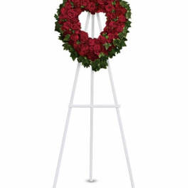 Heart-shaped red rose wreath on a white standing easel