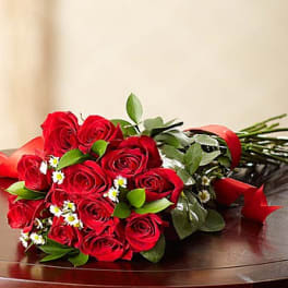 Bouquet of red roses with small white daisies and greenery
