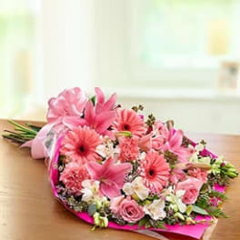 Pink bouquet with lilies, gerbera daisies, and roses wrapped in bright paper