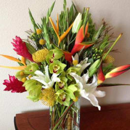 Tropical bouquet with orchids, lilies, and bird-of-paradise in a glass vase