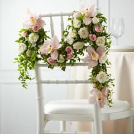 Floral chair decoration with pale pink orchids and white roses