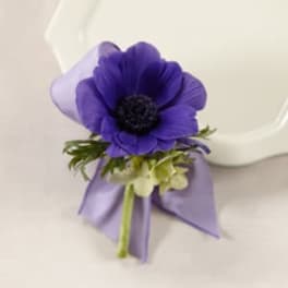 Purple flower boutonniere with a lavender ribbon