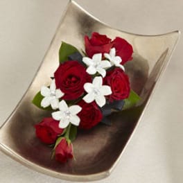 Red roses with white flowers in a curved metallic dish