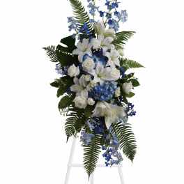 Tall white and blue floral standing spray on an easel