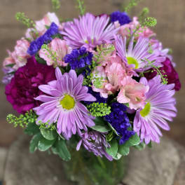 Bouquet of lavender daisies and pink alstroemeria in a glass vase