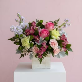 Pink and white mixed flower arrangement in a wooden box