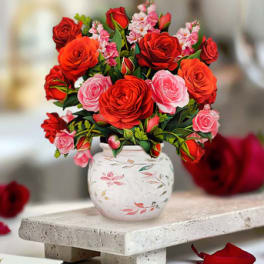 Bouquet of red and pink roses in a white floral vase