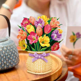 Colorful tulip bouquet in a woven basket with a purple ribbon