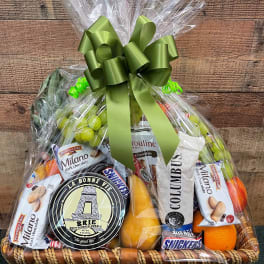 Gift basket with chocolates, cheese, fruit, and snacks wrapped in clear cellophane