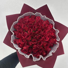 Bouquet of red roses wrapped in burgundy paper