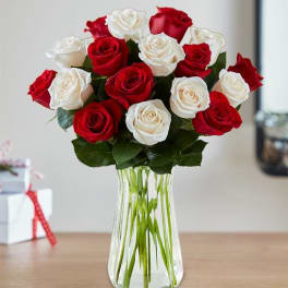Red and white roses arranged in a clear glass vase