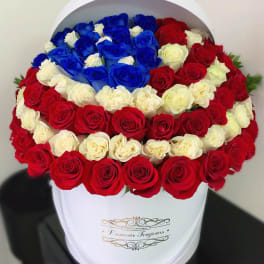 Round box arrangement of red, white, and blue roses