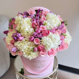 Pink and white bouquet in a round pink hat box