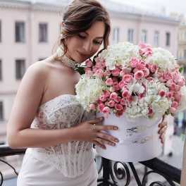 Bride holding a large pink and white rose bouquet in a white box
