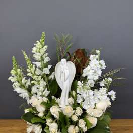 White floral arrangement with a religious statue centerpiece