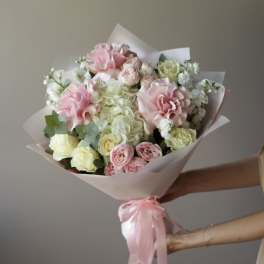 Bouquet of pink and white roses wrapped in pale paper