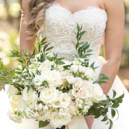 Bride holding a white rose bouquet with greenery