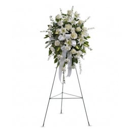 White floral standing spray on an easel with ribbon