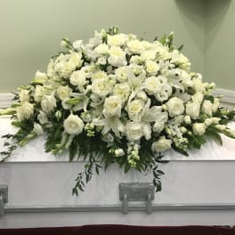 White floral casket spray with roses and lilies