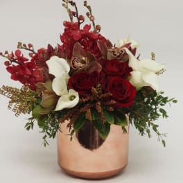 Red roses and white calla lilies in a copper vase