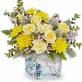 Yellow and white flower arrangement in a patterned glass vase