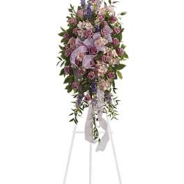 Tall lavender and pink floral spray on a white easel
