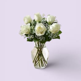 White roses arranged in a clear glass vase
