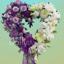 Heart-shaped bouquet of purple and white flowers with a ribbon