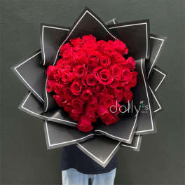 Large bouquet of red roses wrapped in black paper