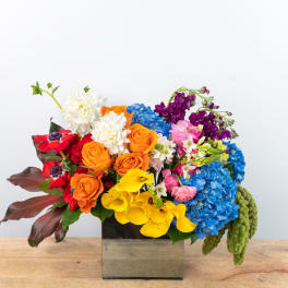 Colorful mixed bouquet in a square glass vase