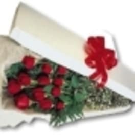 Bouquet of red roses in white wrapping with a red ribbon