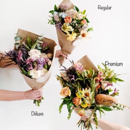 Three wrapped bouquets of mixed flowers in different sizes