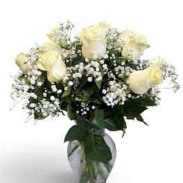 White roses and baby's breath in a clear glass vase