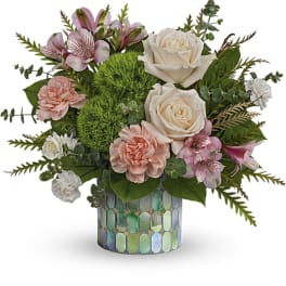 Pink and white floral arrangement in a mosaic glass vase