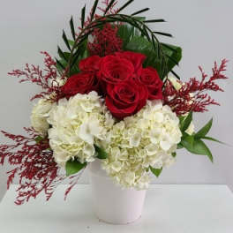 Red roses and white hydrangeas in a white vase