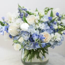 Blue and white bouquet of roses and hydrangeas in a glass vase