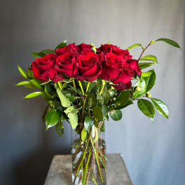 Red roses arranged in a clear glass vase