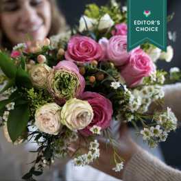Bouquet of pink and cream roses with small white filler flowers