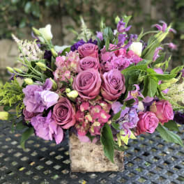 Pink and purple mixed bouquet in a rustic square container