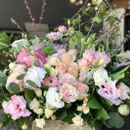 Pastel bouquet of roses and mixed blooms in a wooden box
