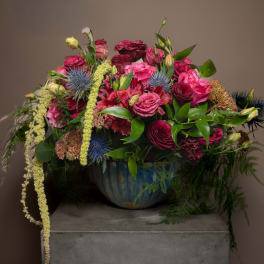 Large mixed bouquet of pink and burgundy flowers in a blue vase
