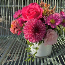 Pink and magenta flowers arranged in a white vase