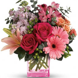 Mixed pink bouquet in a pink glass vase