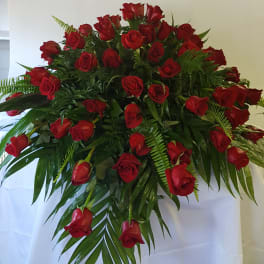 Large bouquet of red roses with palm fronds and fern greenery