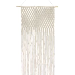 Cream macrame wall hanging with long fringe on a wooden dowel