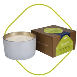 White candle in a metal tin beside a boxed candle set